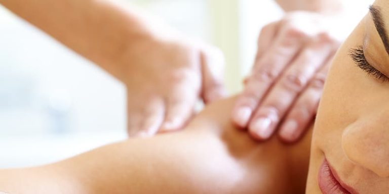 A therapist massaging a client’s shoulders during a body massage