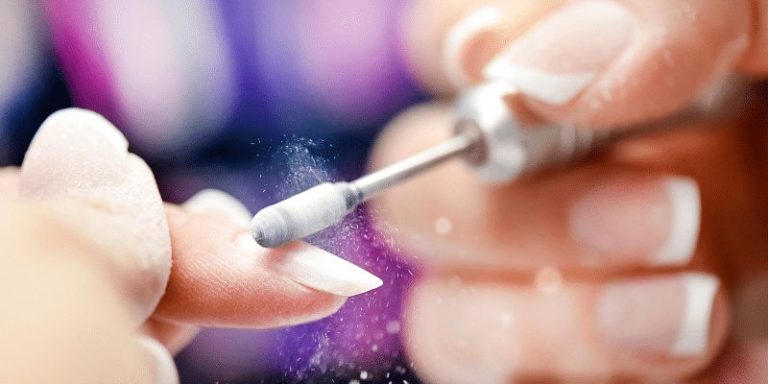 Electric nail file refining a pink nail extension