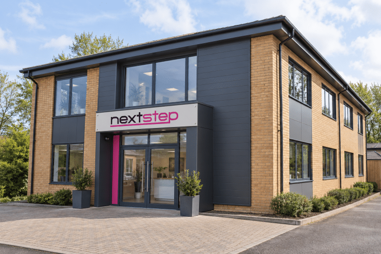 Next Step Beauty office building with the pink nextstep sign above the entrance